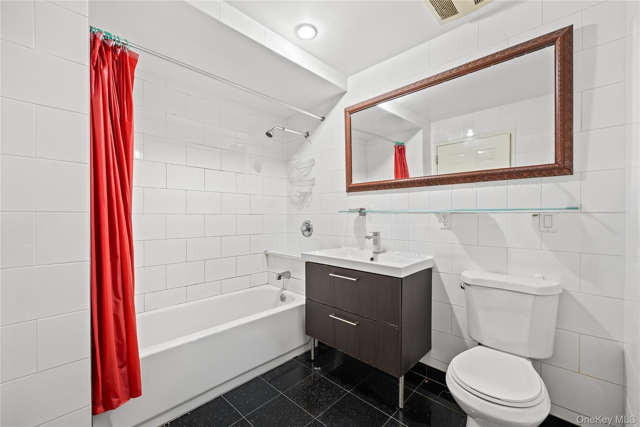 106-07 Northern Boulevard, Unit 5B Queens, NY 11368 - Photo 8 of 18 a bathroom with a toilet a sink and a bathtub