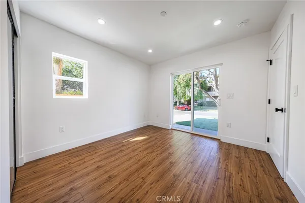 an empty room with wooden floor and a window