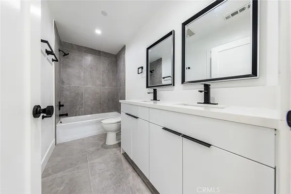 a bathroom with a toilet sink shower and mirror