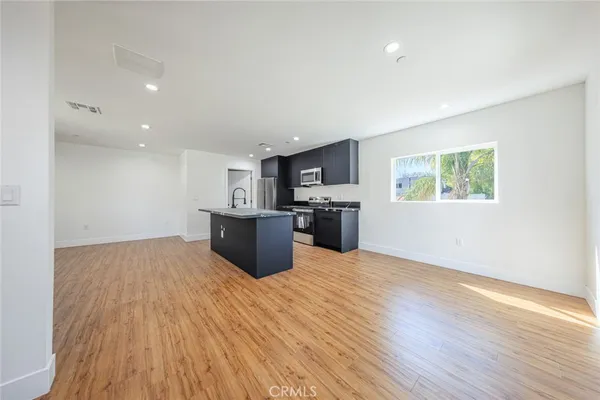 a view of kitchen with microwave and wooden floor