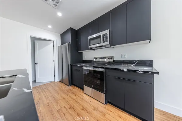 a kitchen with stainless steel appliances granite countertop a refrigerator and a stove top oven
