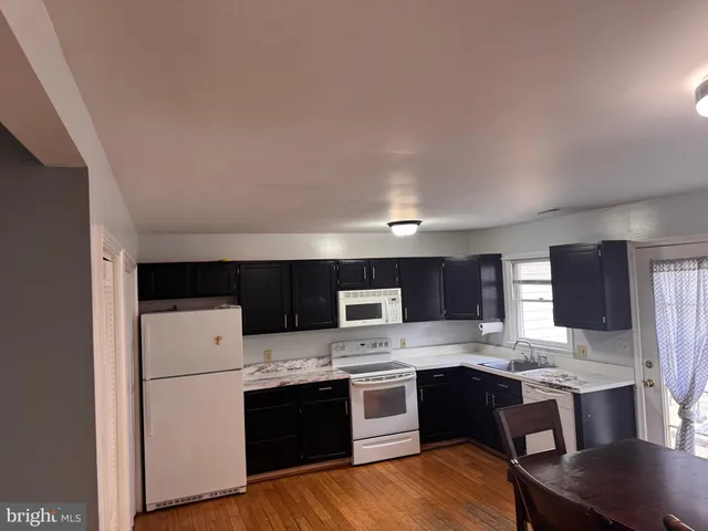 a kitchen with stainless steel appliances a sink cabinets and wooden floor