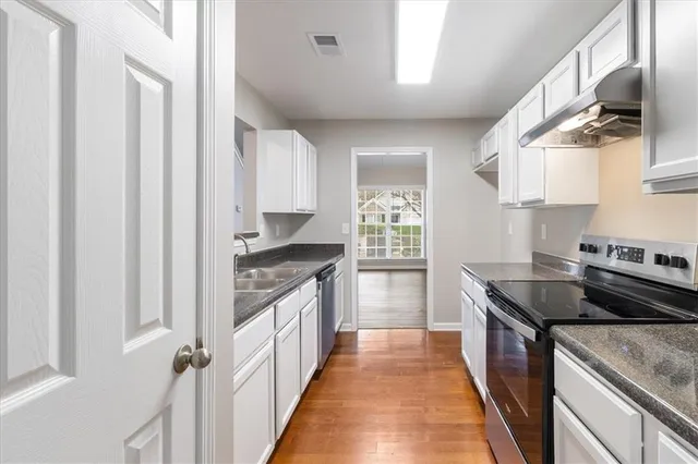 a kitchen with stainless steel appliances granite countertop a stove and a sink