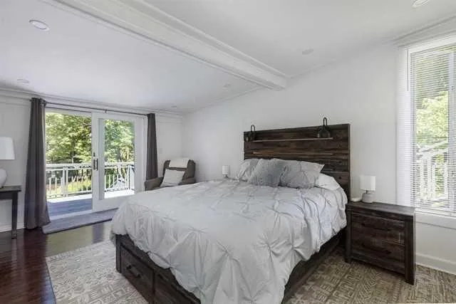 a bedroom with a bed and a large window