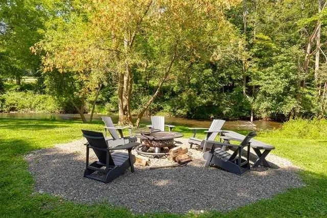 a view of a big yard with table and chairs under an umbrella