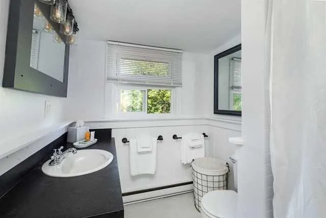 a bathroom with a granite countertop sink toilet a mirror and shower