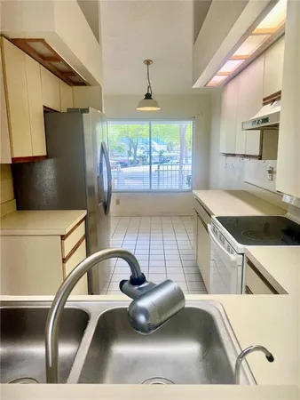 a kitchen with a sink a counter top space and stainless steel appliances