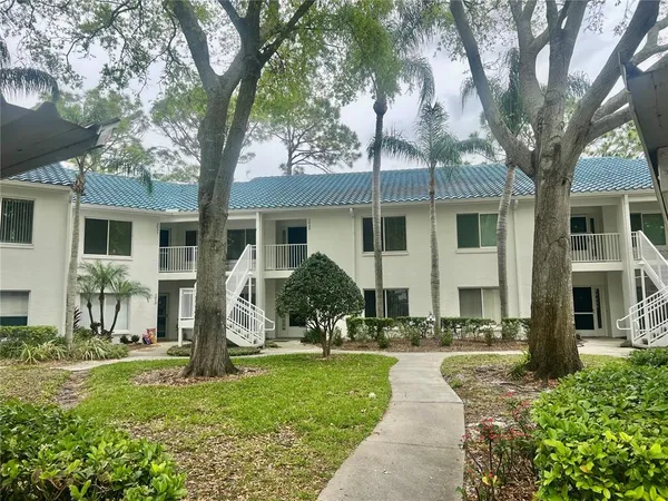 a view of a park with a bench and trees