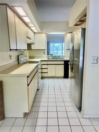 a kitchen with a sink a stove top oven and cabinets