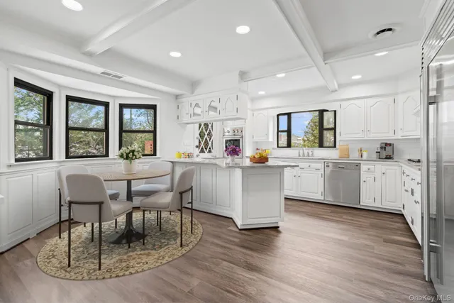 a kitchen with stainless steel appliances granite countertop a stove a sink a dining table and chairs
