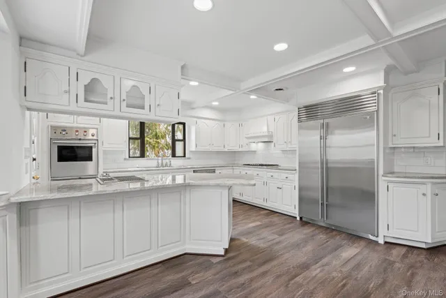 a kitchen with white cabinets and sink