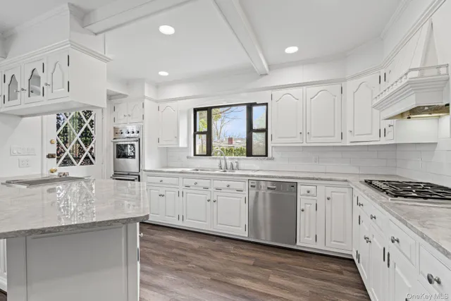 a kitchen with granite countertop white cabinets and window