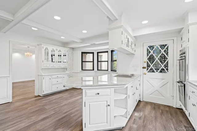a kitchen with white cabinets and sink