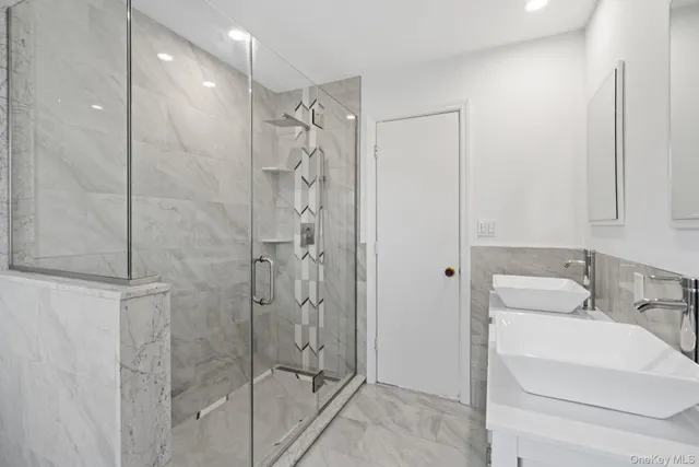 a bathroom with a shower a sink and a mirror