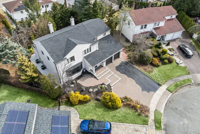 an aerial view of a house with a garden and lake view
