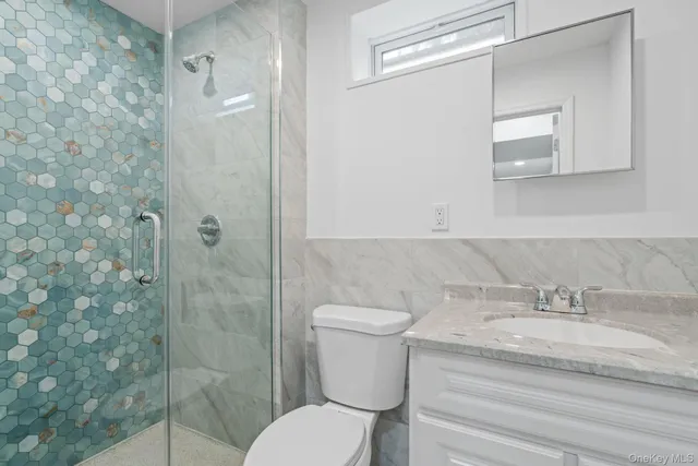 a bathroom with a granite countertop toilet sink and shower