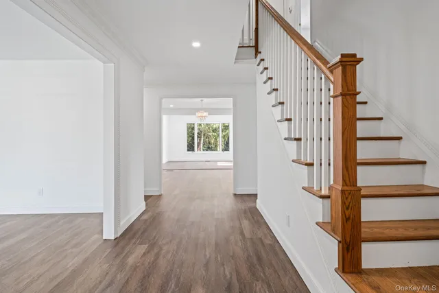 a view of a hallway with wooden floor and staircase