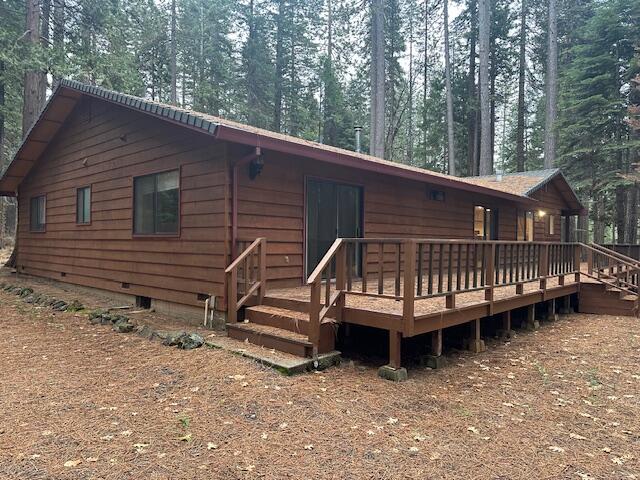 7722 Hidden Meadows Road Shingletown, CA 96088 - Photo 3 of 12 a backyard of a house with a small deck and wooden fence
