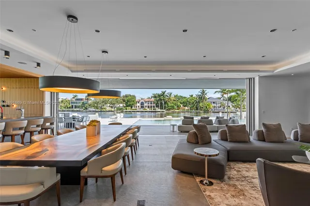 a living room with stainless steel appliances kitchen island granite countertop furniture and a large window