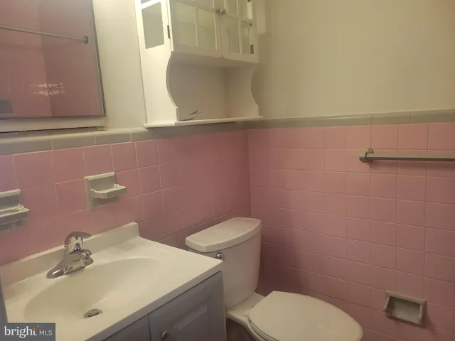 a bathroom with a sink a toilet and mirror