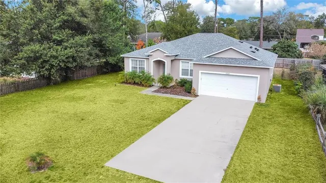 a aerial view of a house with a yard and potted plants