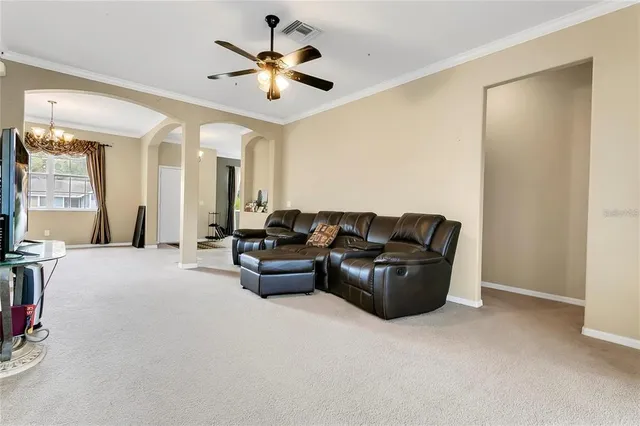 a living room with furniture and a ceiling fan
