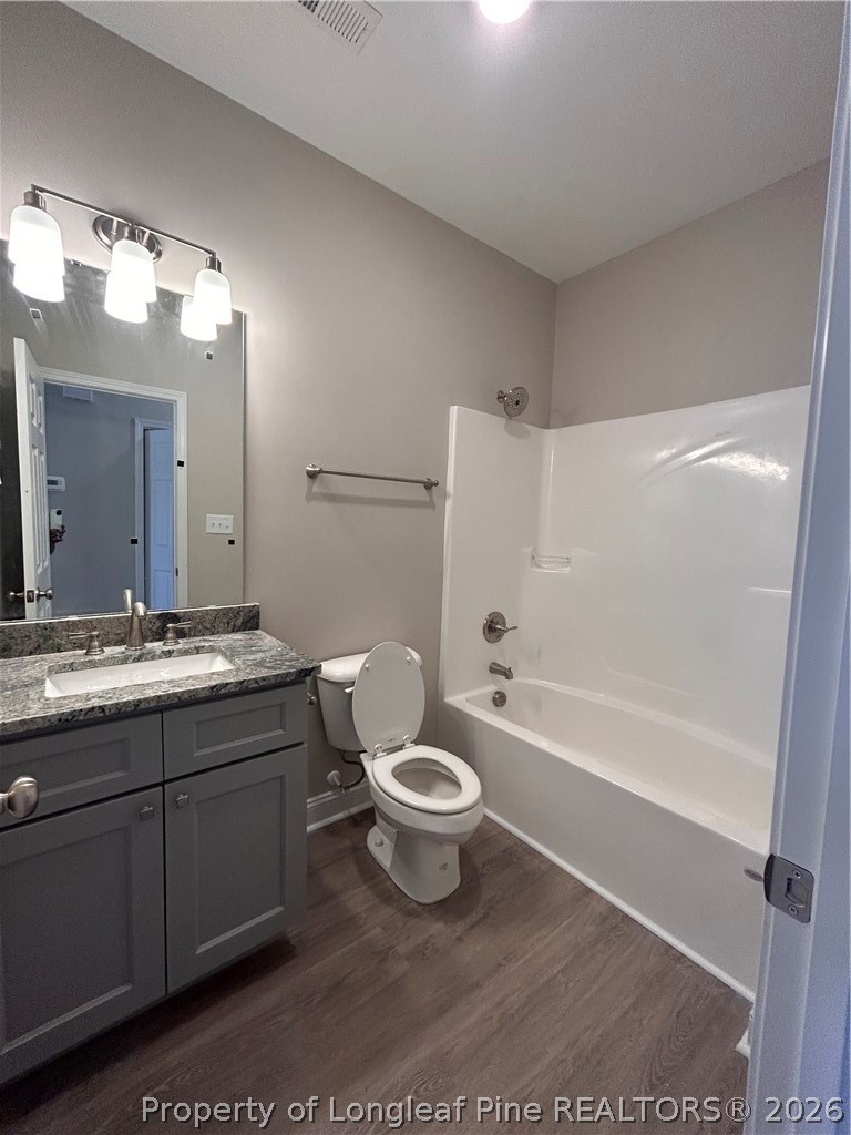 307 Elizabeth Street Spring Lake, NC 28390 - Photo 6 of 12 a bathroom with a sink a toilet a mirror a bathtub and shower