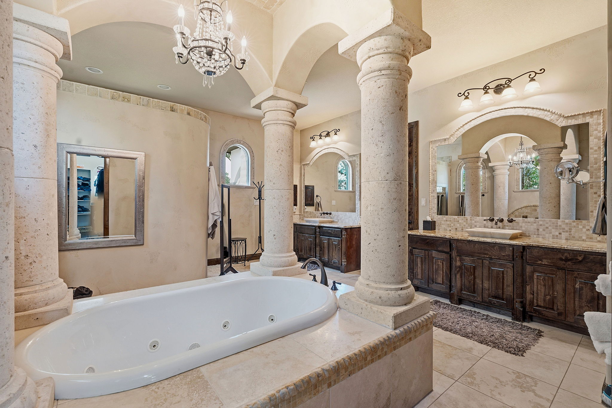 816 Brave Face Street Leander, TX 78641 - Photo 19 of 40 Ornate columns and arched doorways define this luxurious primary bathroom's tranquil, spa-like atmosphere.