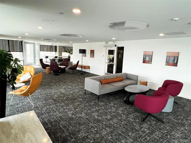 a room with lots of white furniture and a window