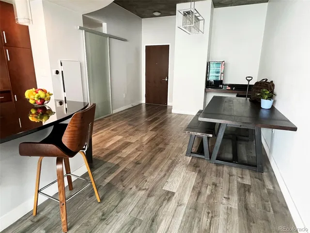 a view of a dining room with furniture a kitchen and chandelier