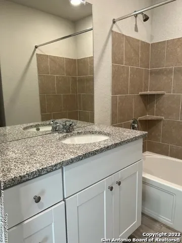 a bathroom with a granite countertop sink a toilet and bathtub