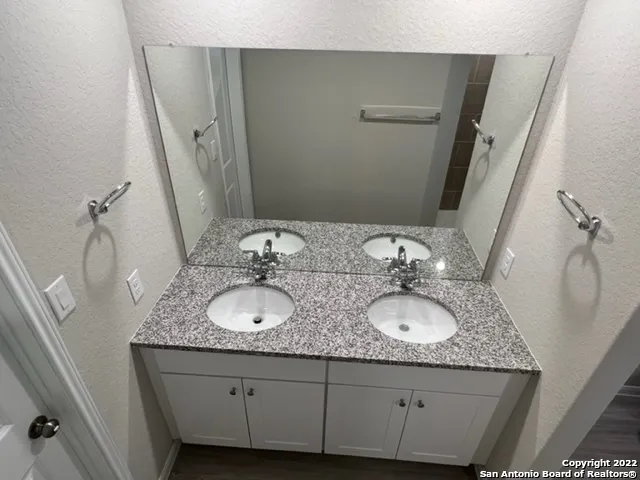 a bathroom with a granite countertop sink a mirror and vanity