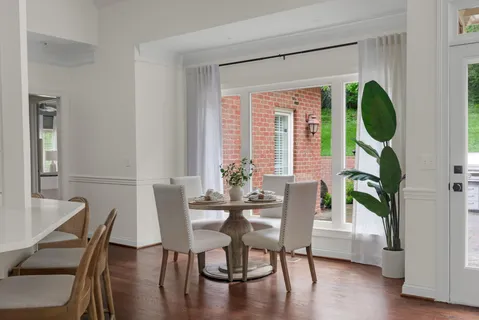 a white kitchen with stainless steel appliances granite countertop a stove a sink dishwasher and a refrigerator with wooden floor