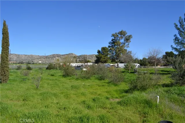 a view of a lush green outdoor space with a swimming pool and valleys in the background