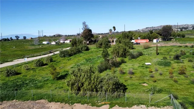 a view of a lush green outdoor space with a swimming pool and valleys in the background