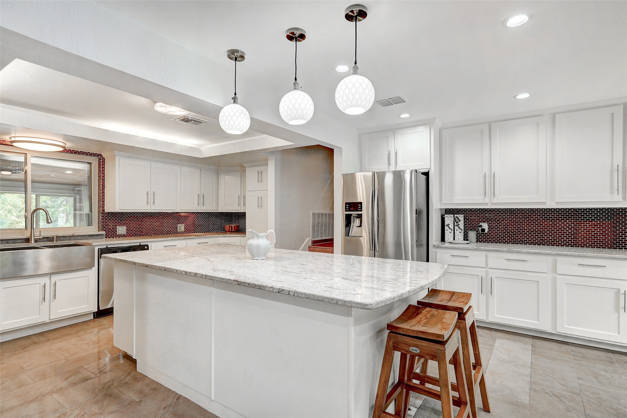 8804 Mountain Ridge Drive, Unit A Austin, TX 78759 - Photo 13 of 37 Kitchen featuring white cabinetry, stainless steel appliances, tasteful backsplash, and a kitchen island