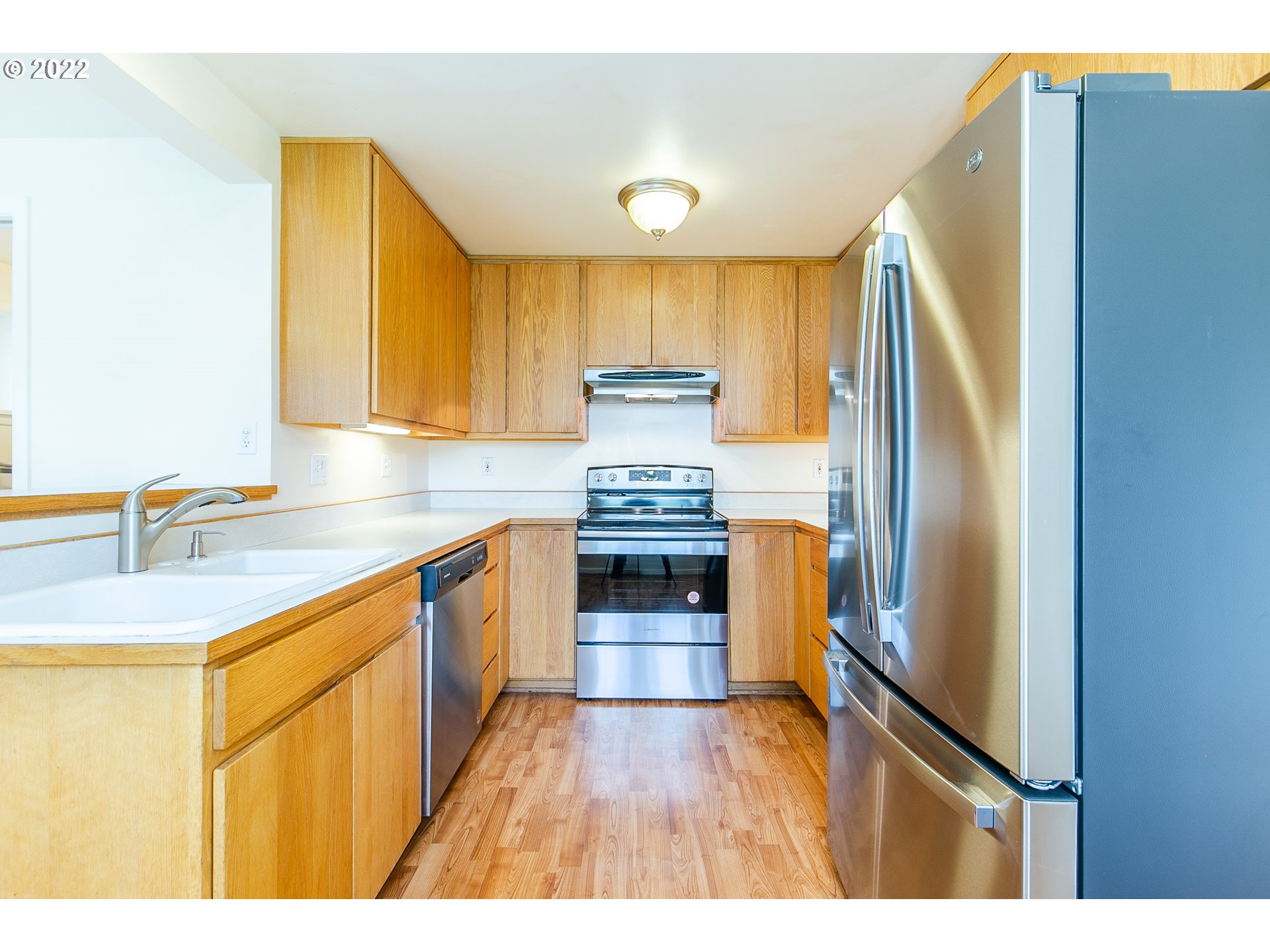 476 U Street Springfield, OR 97477 - Photo 17 of 32 a kitchen with kitchen island a counter top space a sink a refrigerator and a cabinets