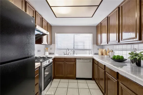 a kitchen with a sink a stove and cabinets