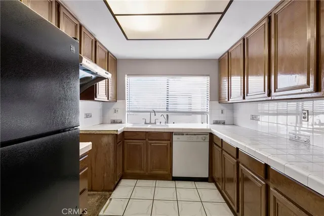 a kitchen with stainless steel appliances granite countertop a sink a stove and a refrigerator