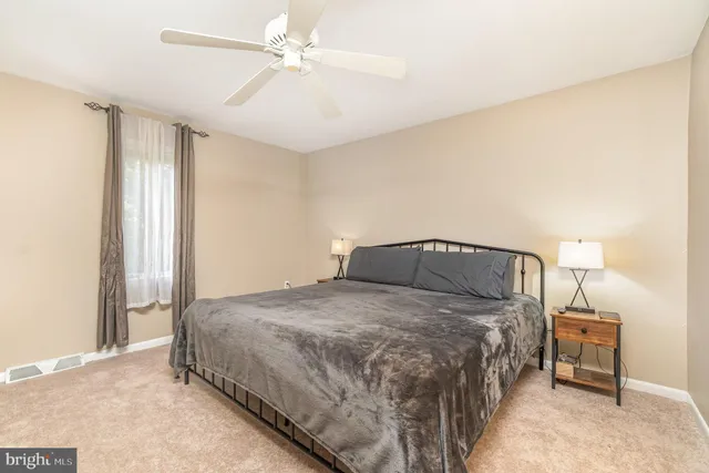 a bedroom with a bed and a ceiling fan