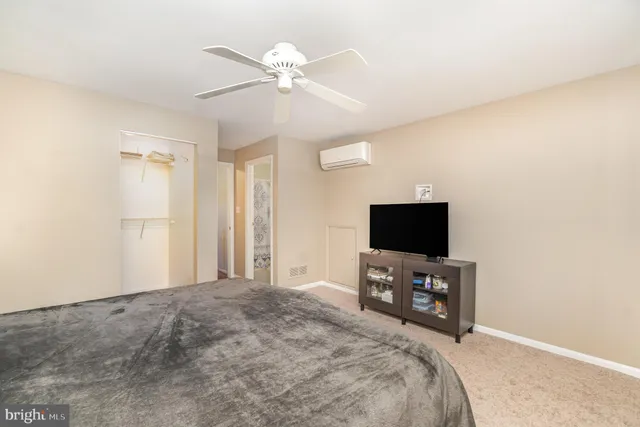 a bedroom with a bed and a flat tv screen on wall