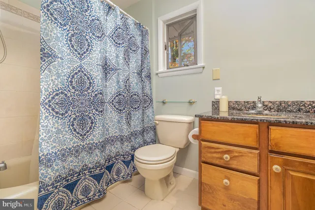 a bathroom with a toilet and a shower curtain