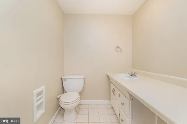 a bathroom with a granite countertop toilet and a sink