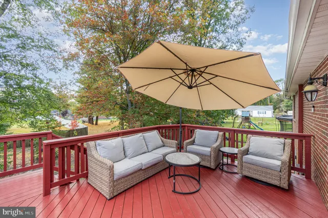 an outdoor sitting area with furniture and wooden deck
