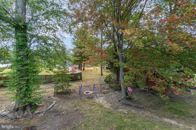 a backyard of a house with trees and outdoor seating