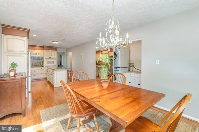 a dining room with furniture a chandelier and wooden floor