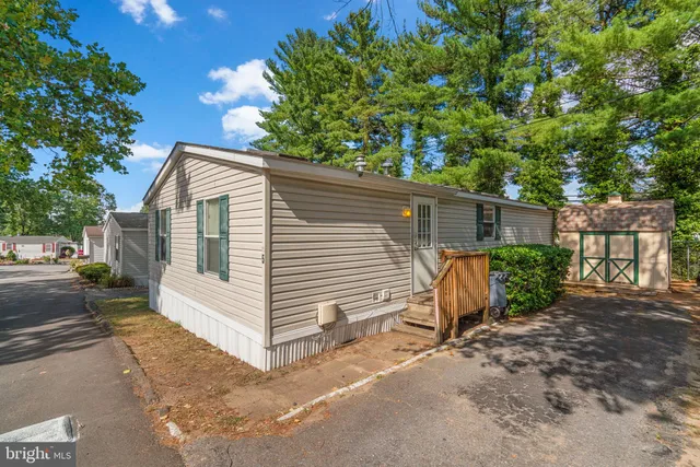 a view of a small house with a tree in the background