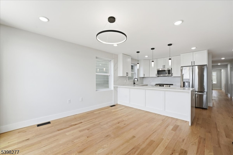 a kitchen with white cabinets and window