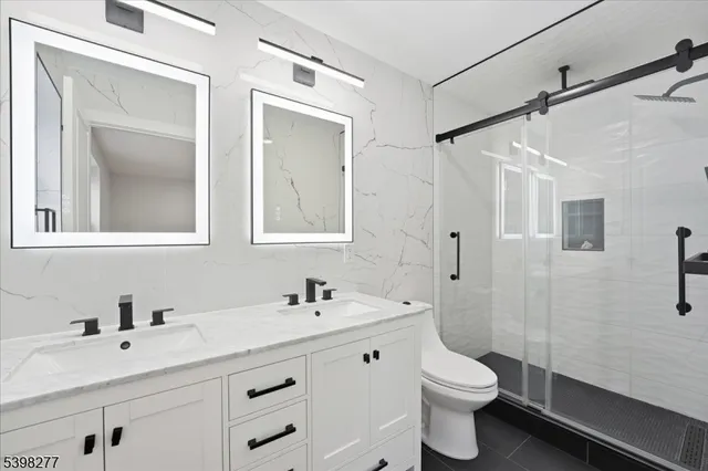 a bathroom with a double vanity sink toilet and shower