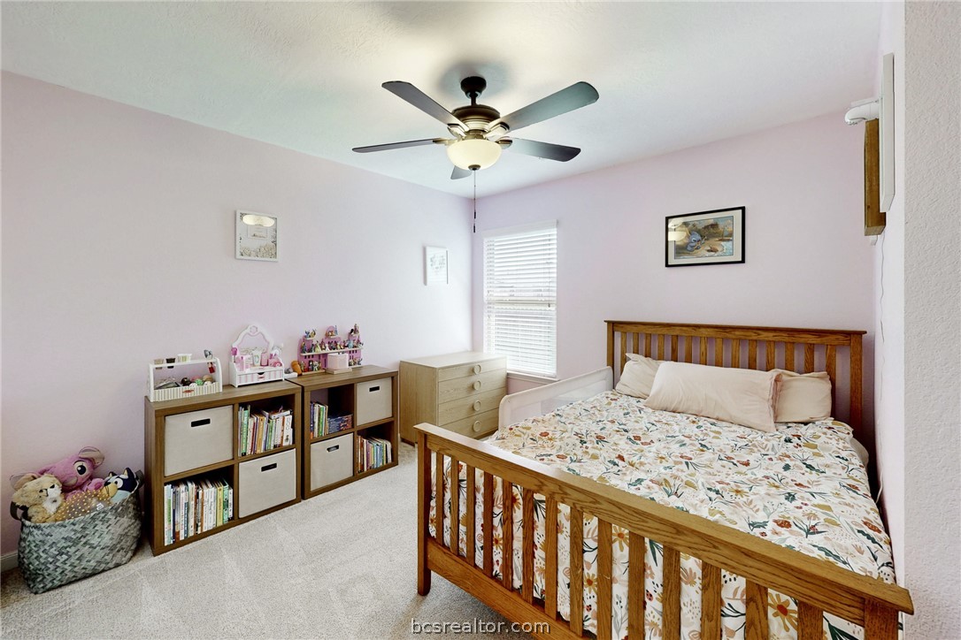 2071 Positano Loop Bryan, TX 77808 - Photo 22 of 31 a bed room with a bed and a chandelier